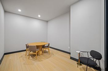 a dining room with white walls and a wooden table and chairs